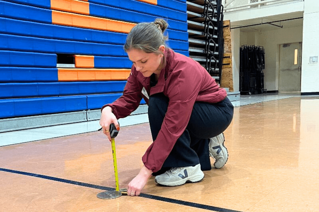 Sports Imports team installing volleyball floorplates and sleeves in a new gym or sports facility